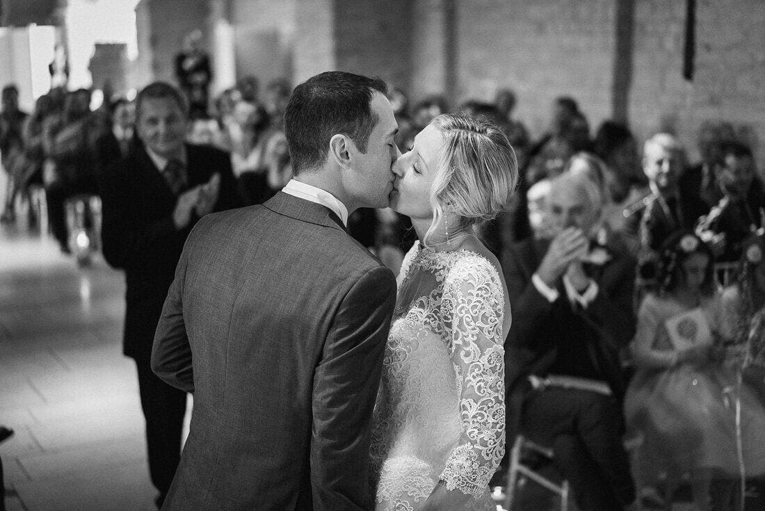 The first kiss as husband and wife at the tithe barn hampshire