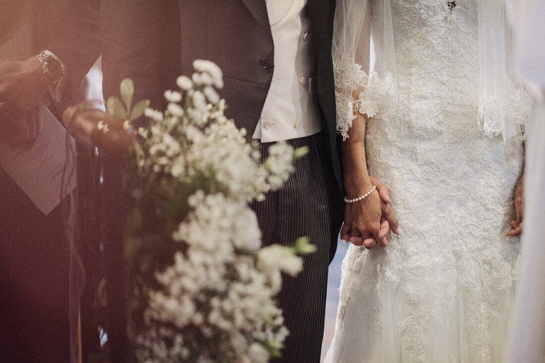 bride and groom hold hands during their vows