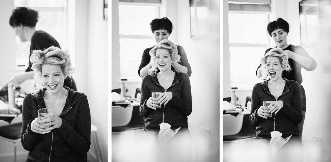 bride laughing while hair and makeup are done