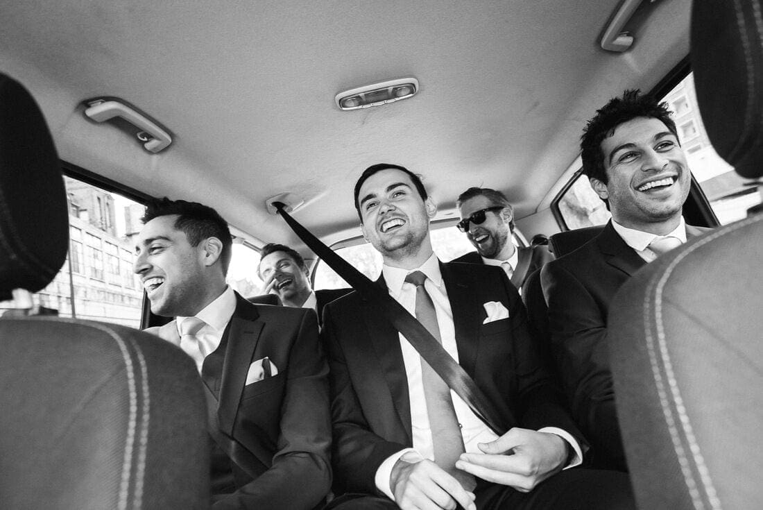 the groomsmen share a joke on the way to the wedding
