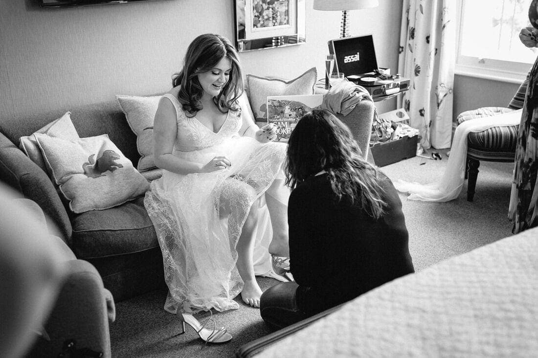the bride puts on her shoes before her wedding ceremony
