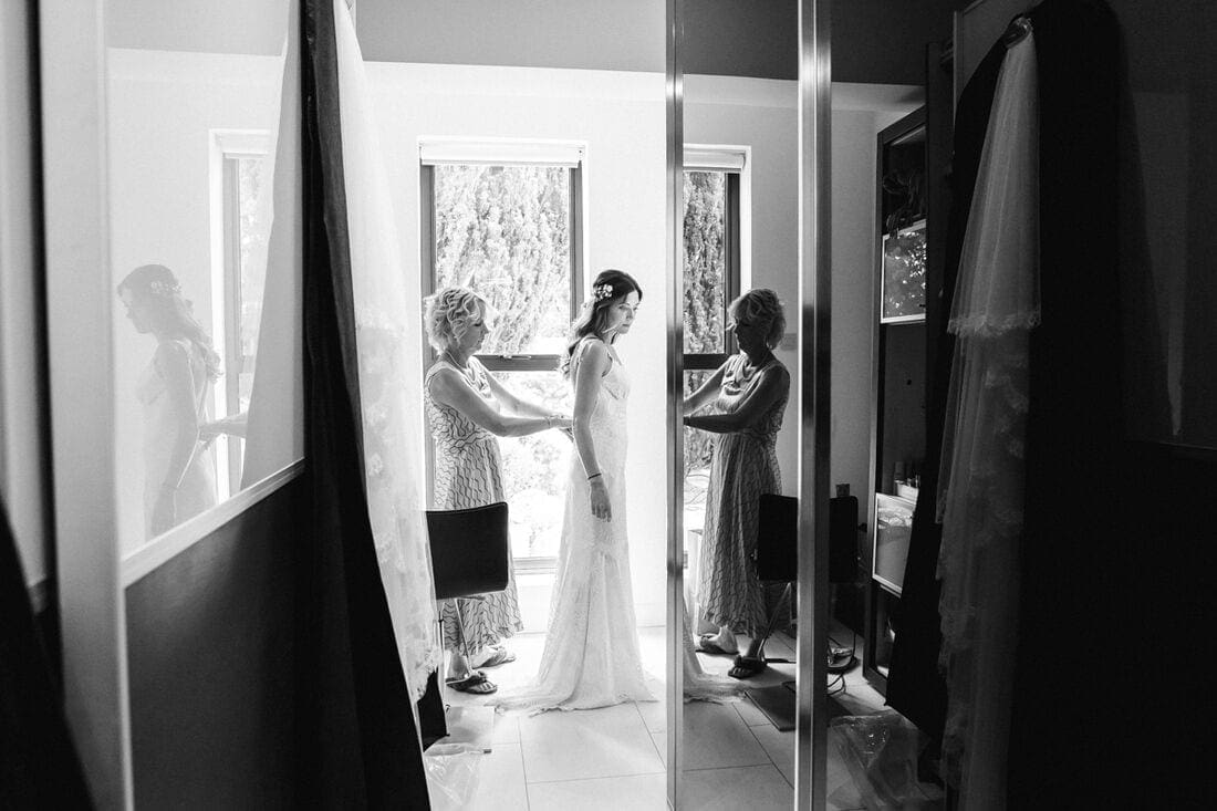 bride and mum put on the wedding dress