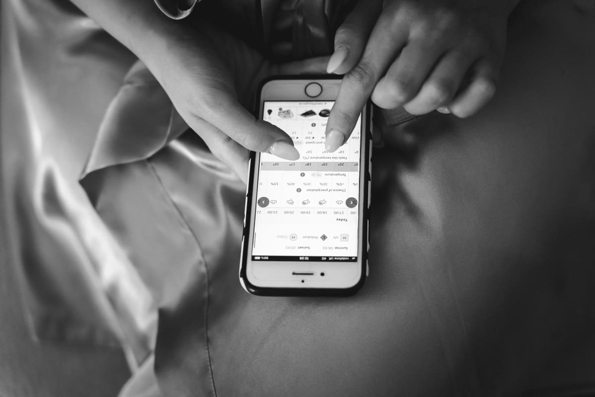 bridesmaid checks the weather on her phone