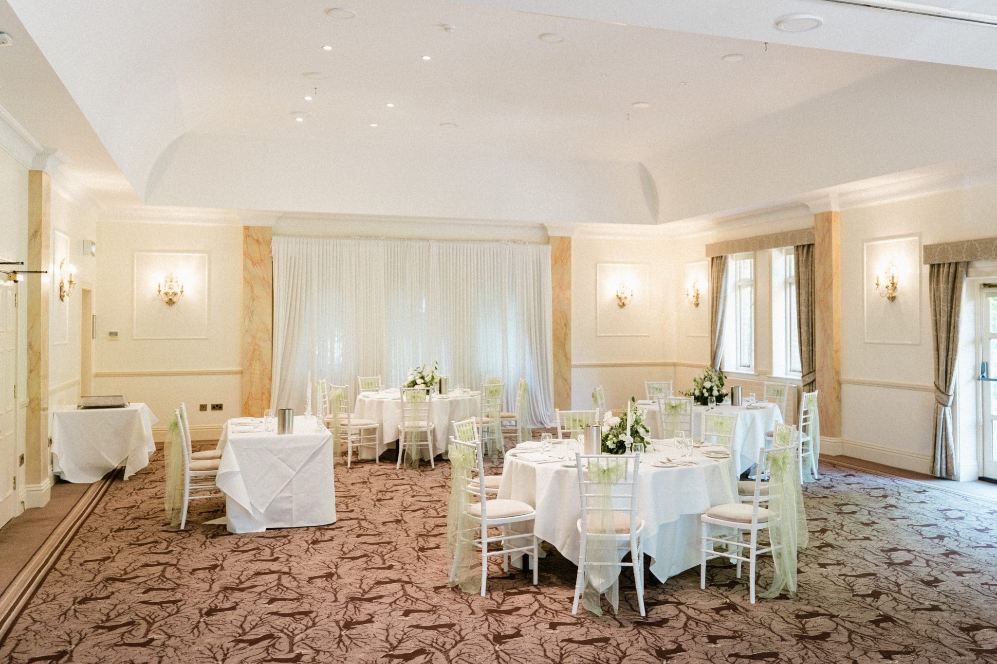 The wedding breakfast room set up for a wedding reception at Careys Manor in Hampshire