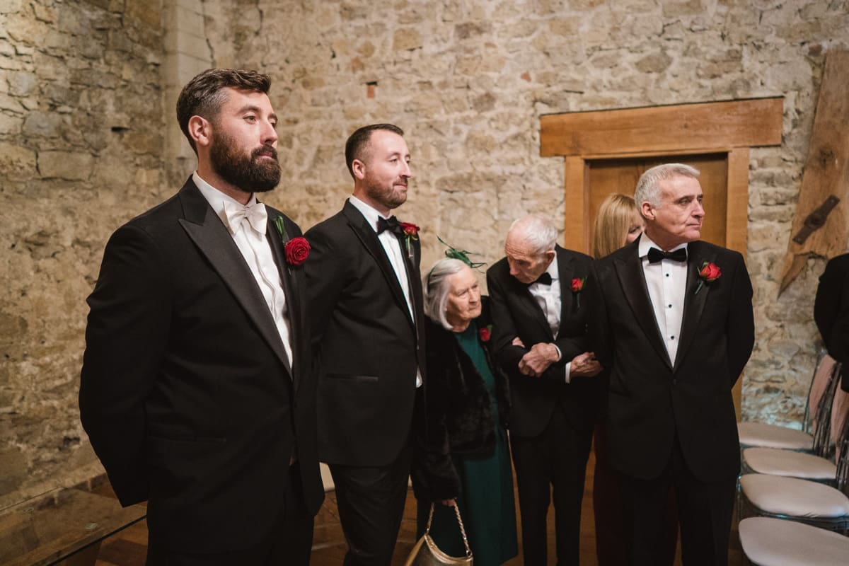 the groom's family watch as the bride walks down the aisle 