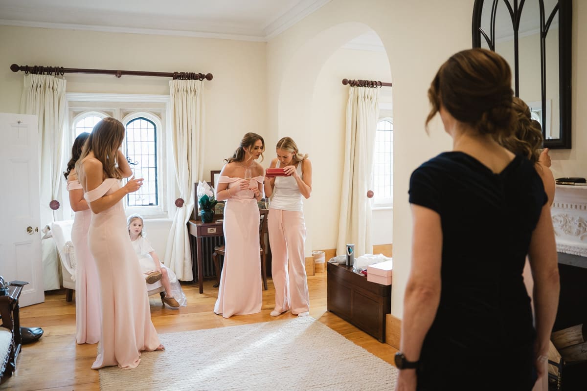the bride opens a gift from her groom on the morning of her wedding