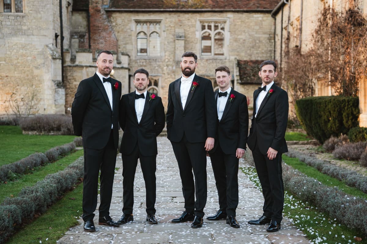 a group photo of the groom with his ushers dressed in black tie